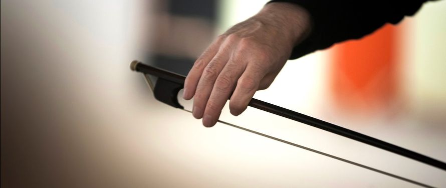 Mano sujetando un arco de violín